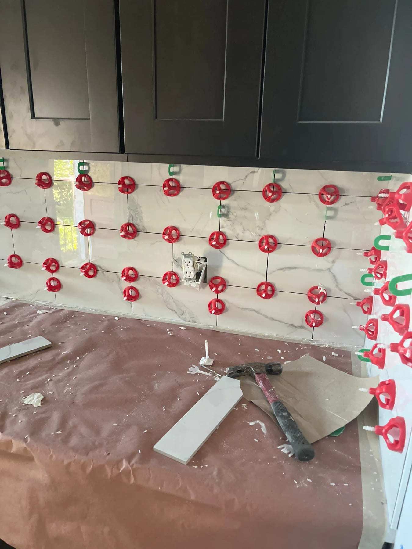 Kitchen backsplash tile being set with leveling clips