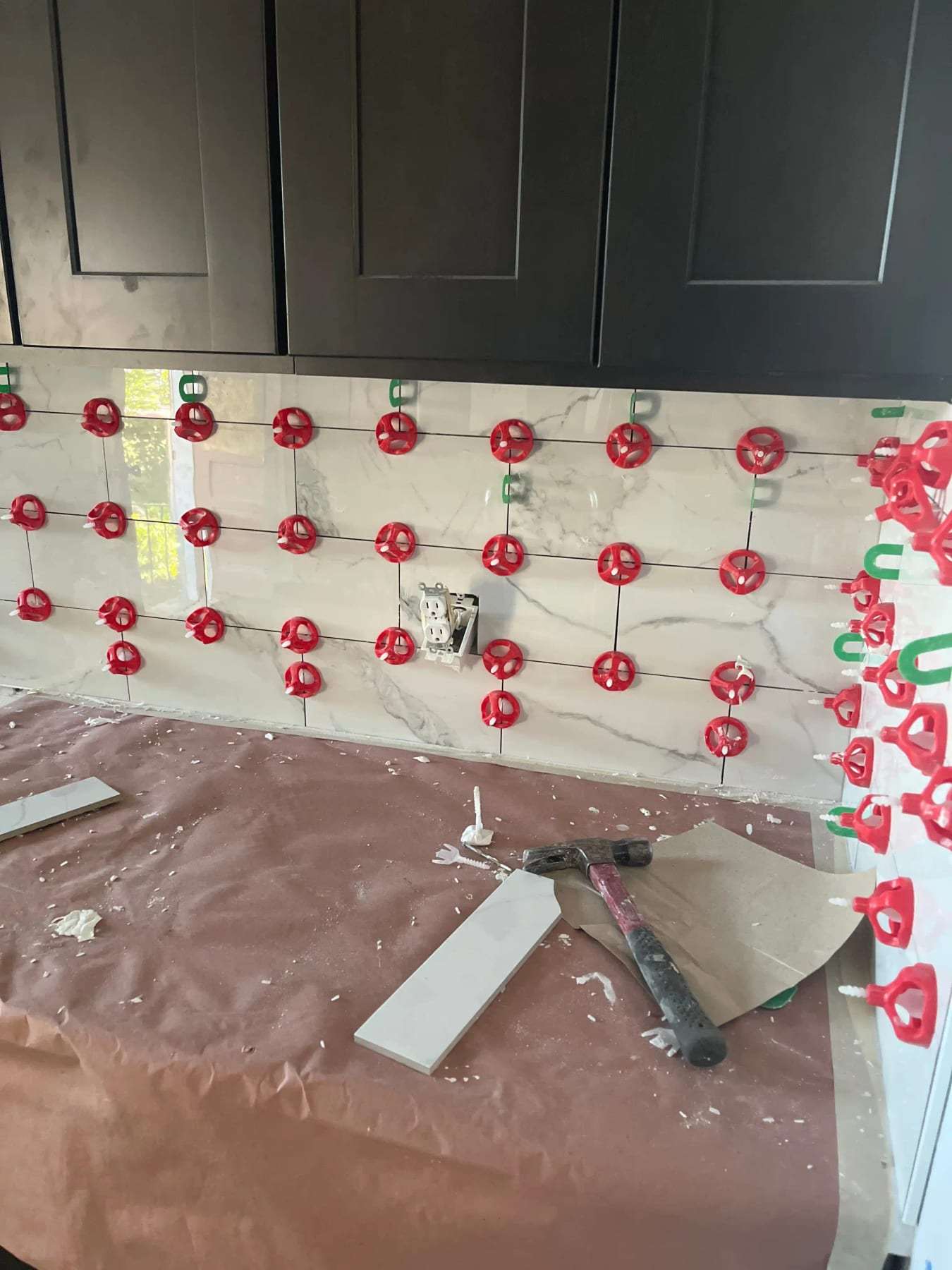 Kitchen backsplash tile being set with leveling clips